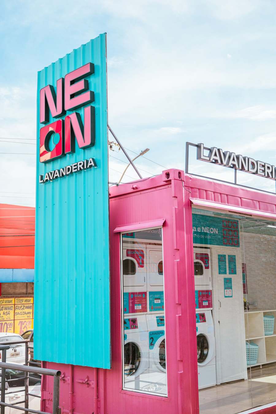 Container da Neon Lavanderia visto de baixo, com letreiro iluminado